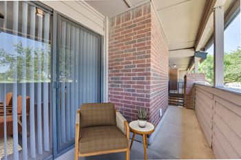 A chair and a table are on a patio.